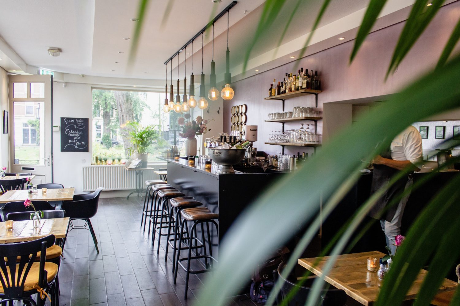 interior shot cafe with chairs near bar with wooden tables